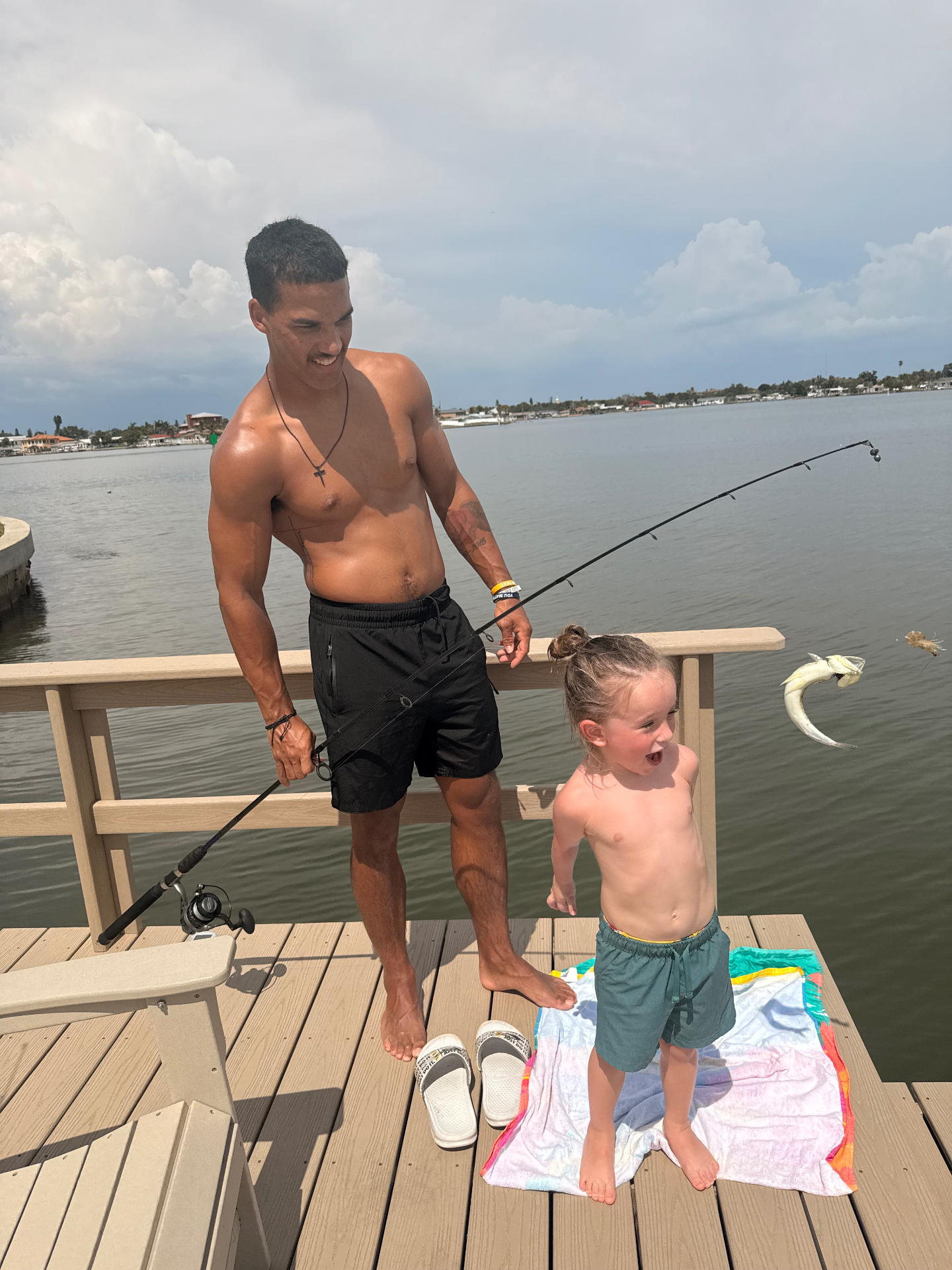 Hudson yelling with excitement as Leon reels in a fish off a dock